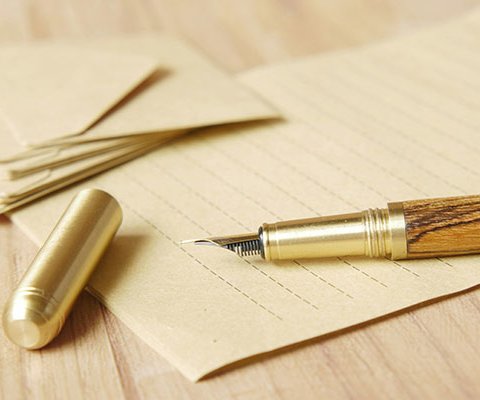 gold fountain pen on old stationery